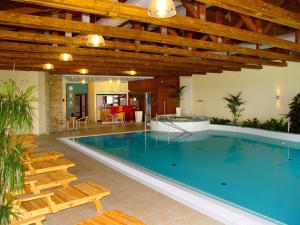 a large swimming pool with chairs and a table at Wellness Hotel Happy Star in Hnanice