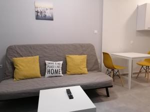 a grey couch with yellow pillows in a living room at Central City Kristalli studio in Thessaloniki