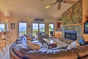 a living room with a leather couch and a stone fireplace at High Gravity Banner Elk Custom Chalet with Views! in Banner Elk