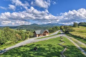 a house on a hill next to a road at High Gravity Banner Elk Custom Chalet with Views! in Banner Elk