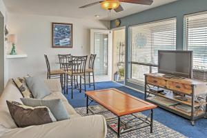 a living room with a couch and a tv and a table at Spicewood Condo on The South Shore of Lake Travis! in Spicewood