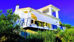 a yellow and white house with a white awning at Apartment AMMIRARE Rab in Rab