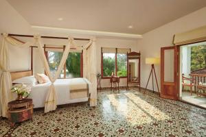 a bedroom with a bed with a canopy at amã Stays & Trails, Pathiramanal Villa in Alleppey