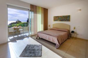 1 dormitorio con 1 cama y balcón con mesa en Zeus Hotel - Aparthotel - Meeting & Congress, en Catania