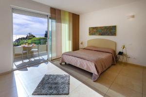 a bedroom with a bed and a balcony with a table at Zeus Hotel - Aparthotel - Meeting & Congress in Catania +51 photos