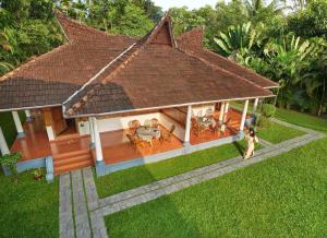 a model of a house with a woman walking in front of it at amã Stays & Trails, Pathiramanal Villa in Alleppey