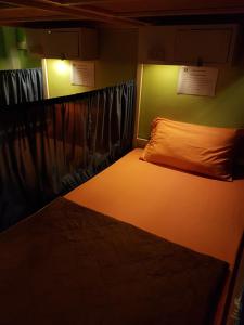 Una cama en una habitación con luz. en Sleep Tight Hostel at Koh Phangan, en Haad Rin