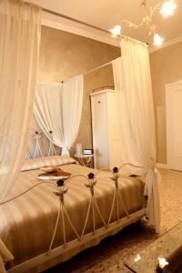 a bedroom with a canopy bed with white curtains at A Class in Lecce
