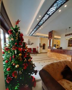 a living room filled with furniture and a christmas tree at Rumman Hotel in Madaba