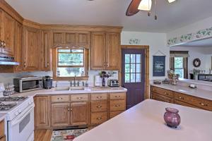 a kitchen with wooden cabinets and white appliances at Spacious Finger Lakes Vacation Rental on 6 Acres! in Naples