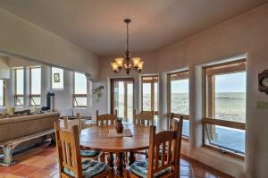 a dining room with a table and chairs and windows at Traditional Taos Home 26 Acres with Mountain Views in Taos