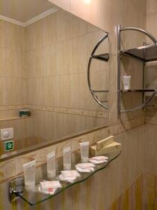 a bathroom with a glass shelf and a mirror at Hotel TATRA in Malacky