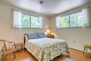 a bedroom with a bed and a chair and two windows at Stair-Free Lexington Home with Blue Ridge Mtn Views! in Lexington