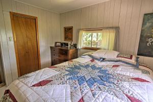 um quarto com uma colcha em cima de uma cama em Rustic De Tour Village Cabin with Deck on Lake Huron! em De Tour Village