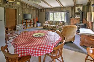 uma sala de estar com uma mesa e um sofá em Rustic De Tour Village Cabin with Deck on Lake Huron! em De Tour Village