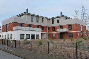 een rood-wit gebouw aan de straatkant bij Dünenhaus Wohnung 9 in Lübeck