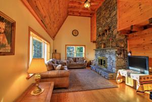 a living room with a stone fireplace and a couch at Bearpen Lodge on 125 Acres - Near Belleayre Mtn! in Vega