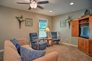 uma sala de estar com um sofá e cadeiras e uma televisão em Wooded Gilbertsville Hideaway on Kentucky Lake! em Draffenville