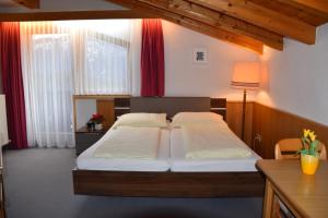 una camera da letto con due letti e una scrivania di Gästehaus Friedl a Imst