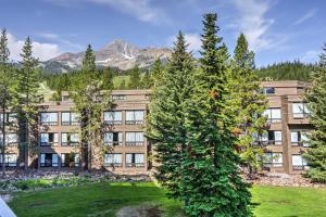 an apartment building with trees in front of it at Big Sky Condo with Mountain Views, Hike, Ski and Fish! in Big Sky