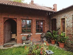 a brick house with a yard with plants at Pokoje do wynajęcia in Nowogrodziec