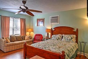 a bedroom with a bed and a couch and a ceiling fan at Paradise Cove Cabin with Boathouse and Dock in Guntersville