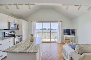 eine Küche und ein Wohnzimmer mit einem Sofa und einem Tisch in der Unterkunft Coastal Rhode Island Home with Kayaks, Deck and Grill! in Portsmouth