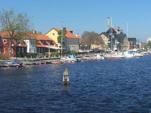 a dock in the middle of a river with boats at Gårdshus Torget Åhus in Åhus