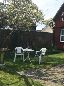 two chairs and a table in a yard at Gårdshus Torget Åhus in Åhus