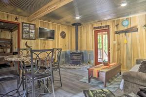 a living room with a table and a fireplace at Kentucky Cabin with 2 Fishing Ponds and Trail Access in New Concord