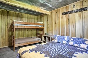 a bedroom with a bed in a room with wooden walls at Kentucky Cabin with 2 Fishing Ponds and Trail Access in New Concord