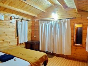 a bedroom with a bed in a log cabin at Agonda Paradise in Agonda