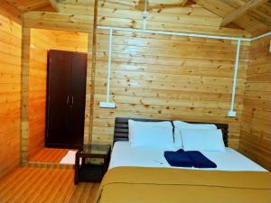 a bedroom with a bed with a wooden wall at Agonda Paradise in Agonda