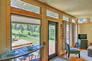 een woonkamer met een tafel en een groot raam bij Scenic Lead Cabin Steps to Terry Peak Ski Area! in Lead