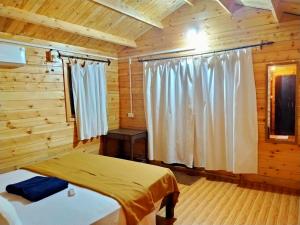 a bedroom with two beds in a log cabin at Agonda Paradise in Agonda