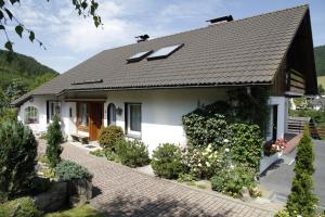 een klein wit huis met een zwart dak bij Ferienwohnung Bücker in Schmallenberg