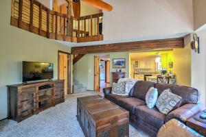 ein Wohnzimmer mit einem braunen Sofa und einem TV in der Unterkunft Wooded Retreat with Deck 4 Mi to Downtown Flagstaff in Flagstaff