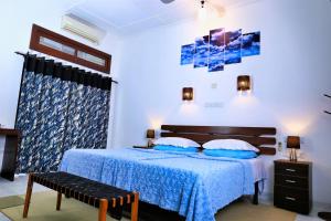 1 dormitorio con 1 cama con colcha azul en Camellia Dwelling en Hikkaduwa