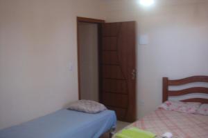 ein kleines Schlafzimmer mit 2 Betten und einer Tür in der Unterkunft stellamares apartamentos in Salvador