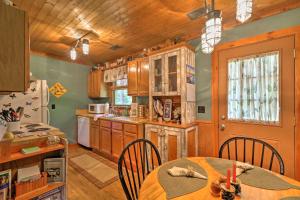 a kitchen with wooden cabinets and a table and chairs at Cozy Pine Mountain Cabin with Screened Porch and Yard! in Pine Mountain