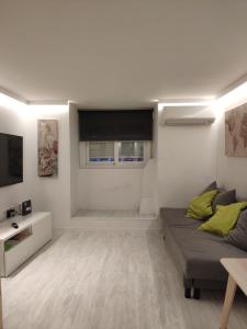 sala de estar con sofá y TV en Cozy Apartment Malasaña FREE Parking, en Madrid