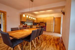 cocina y comedor con mesa de madera y sillas en Das Wetterstein, en Ehrwald