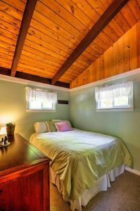 a bedroom with a bed with a wooden ceiling at Breathtaking Newbury Cottage with Deck on Chalk Pond in Newbury