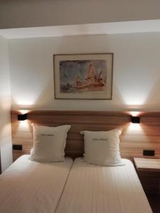 a bed with two white pillows in a room at LEHOUCK kamers ontbijt in Koksijde +12 photos