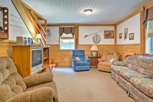 ein Wohnzimmer mit einem Sofa und einem TV in der Unterkunft Rustic Taswell Cabin Grill and Walk to Patoka Lake! in Taswell
