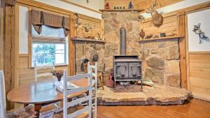 - un salon avec une cheminée en pierre et une table dans l'établissement Rustic Taswell Cabin Grill and Walk to Patoka Lake!, à Taswell