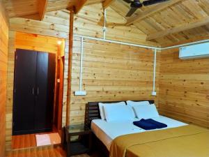 a bedroom with a bed in a wooden room at Agonda Paradise in Agonda