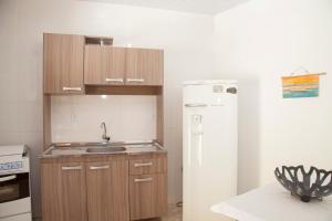 a kitchen with a refrigerator, stove, sink and dishwasher at Morada do Gabriel in Guarda do Embaú