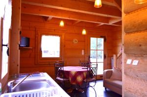 a kitchen and dining room with a table in a cabin at La Clé Des Champs in Biltzheim