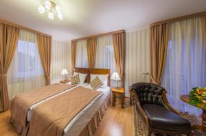 a hotel room with a bed and a chair at Bystrytsya Lux in Ivano-Frankivsk +65 photos